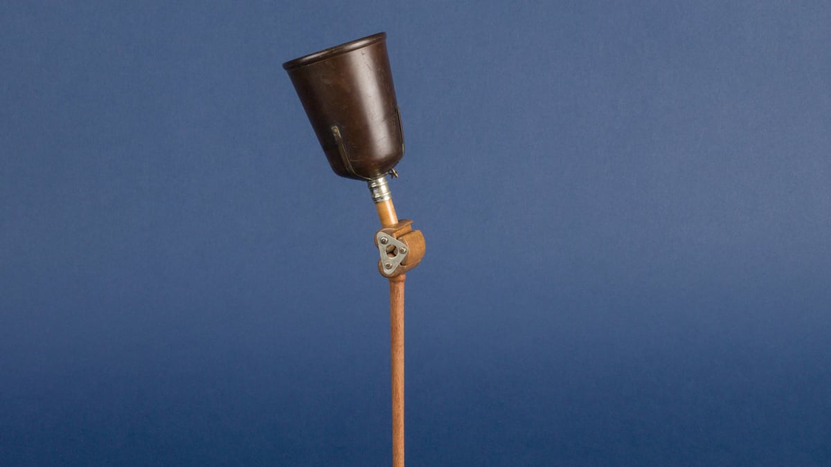 A prosthetic leg stands upright against a solid blue background.
