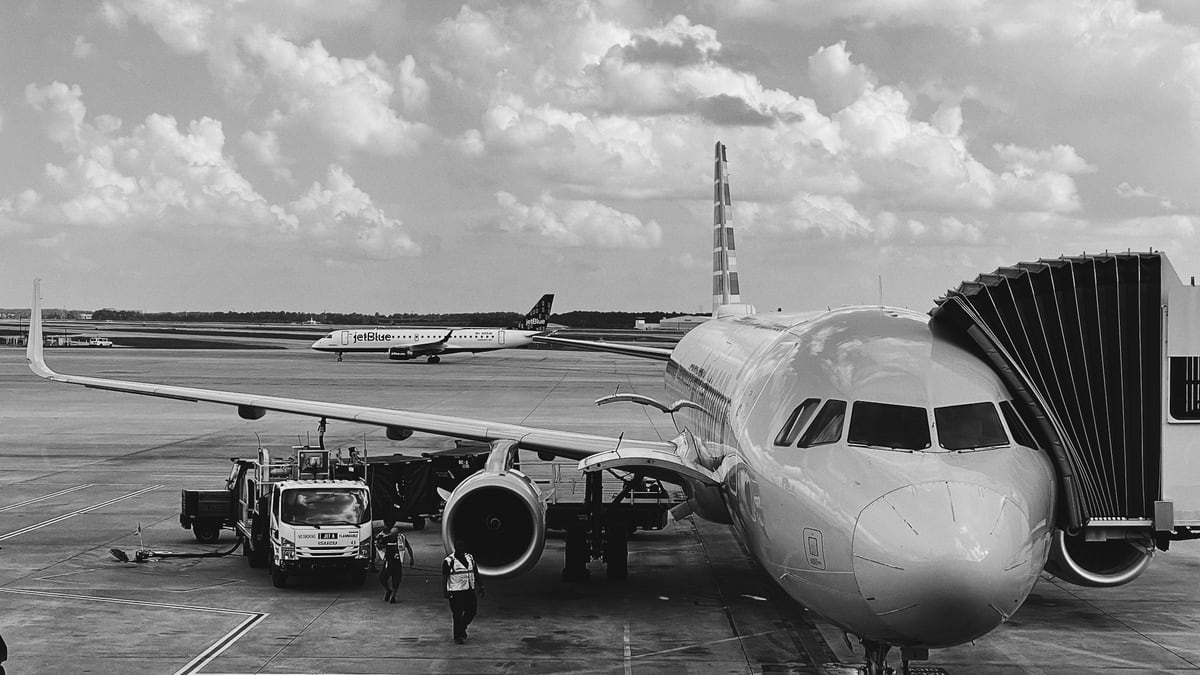 grayscale photo of airplane on airport
