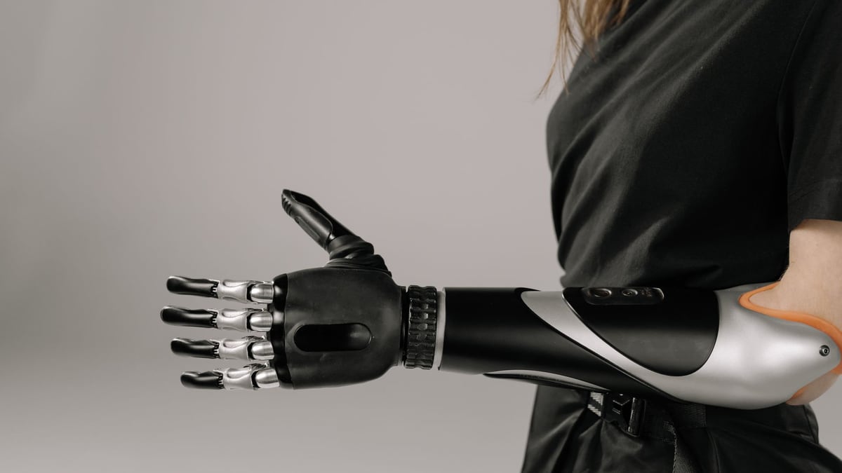 Close-up of a woman wearing a sleek, modern prosthetic arm. Studio shot emphasizes technology and innovation.