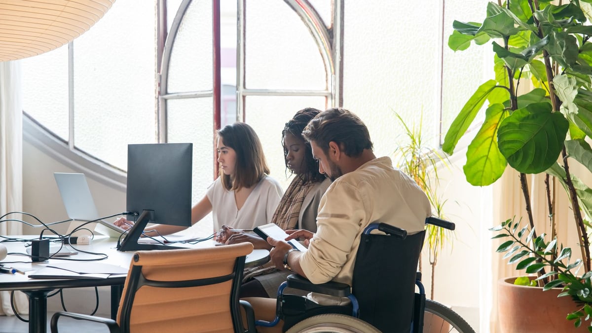 Diverse team working together in a modern office setting with inclusive collaboration.